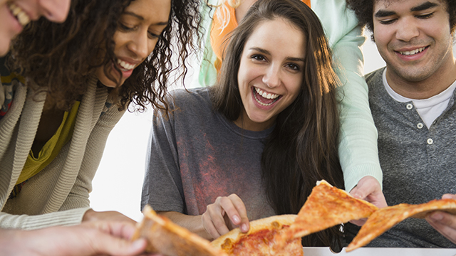 Grupo amigos comiendo pizzas