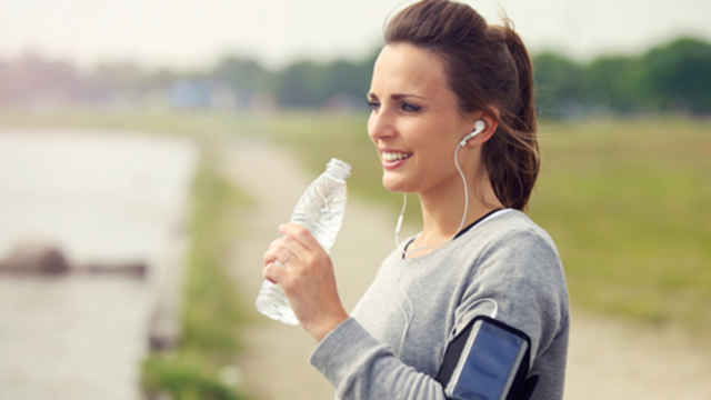 Mujer ejercitando y tomando una botella de agua