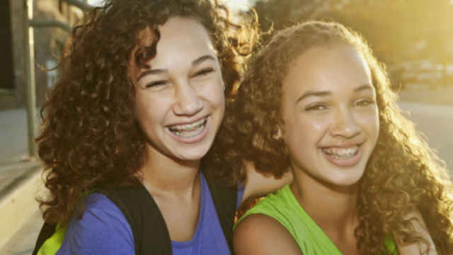Adolescentes sonriendo con tratamiento de ortodoncia